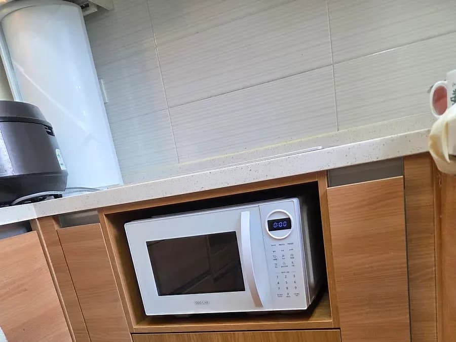 전자레인지를 넣은 나무색 수납장